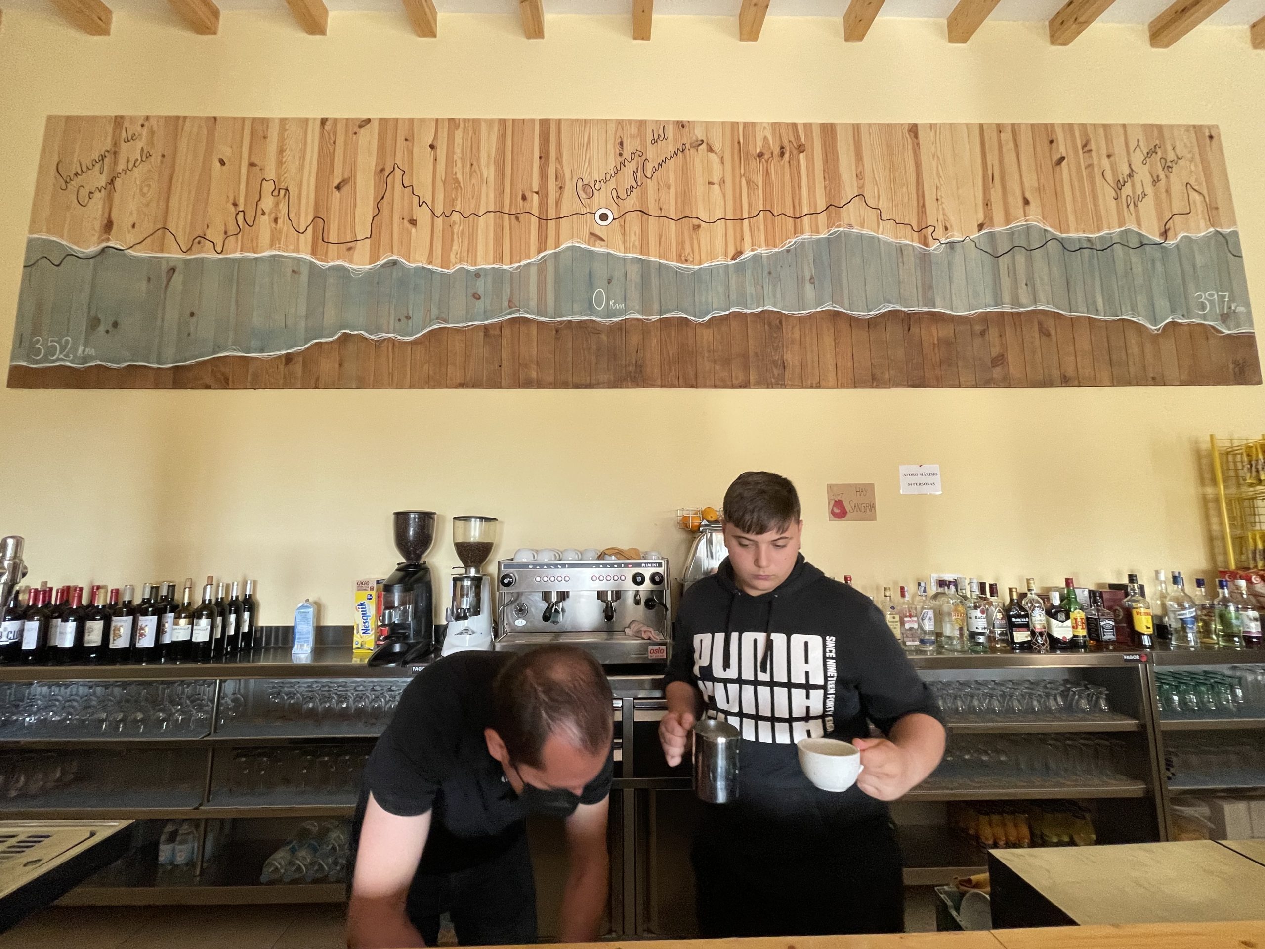 Secondo il cartellone alle spalle dei baristi a Bercianos si sono fatti 397 km da Saint Jean e ne mancano 352 a Santiago